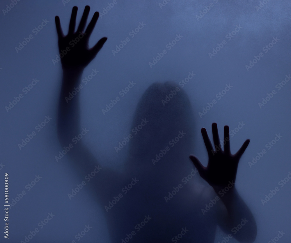 Horror, mystery and shadow of a woman on a window for fear, escape or nightmare. Dark, hands and a ghost, girl or person with paranormal activity, spooky behavior or strange movement in a studio