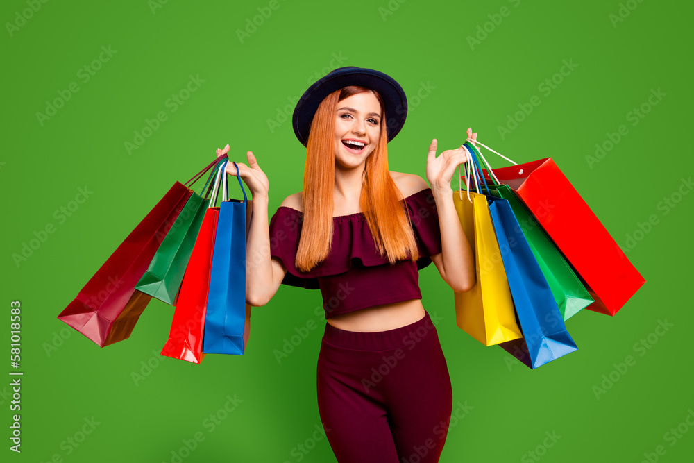 Black friday Happy model girl returns from shopping mall holding colorful bags isolated on yellow background