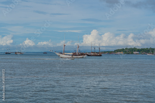 View from the ferry to Waisai at Sorong with cruises and tour boats, background blue sky, copy space photo