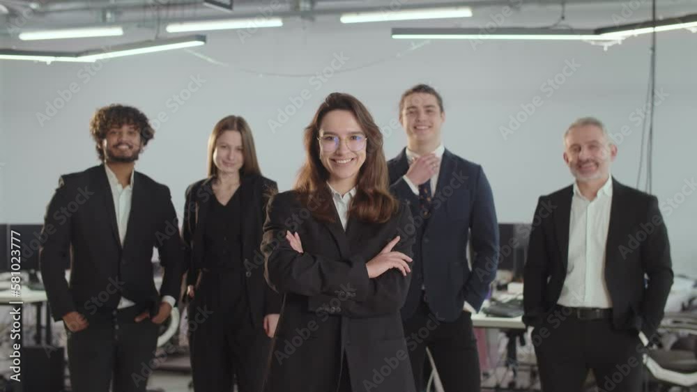 The owner of a consulting company stands in front of her employees. Smiling team providing consulting services. Successful people in business suits. The owner of a consulting company stands in front of her employees. Smiling team providing consulting services. Successful people in business suits.