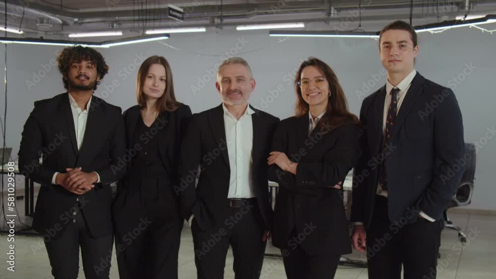 Diverse team of business people posing for a photo together. Successful team of businessmen in business suits are having a photo shoot in the office. Diverse team of business people posing for a photo together. Successful team of businessmen in business suits are having a photo shoot in the office.