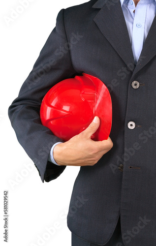 Male businessman holding orange helmet over building construction