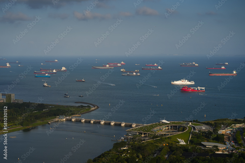 Singapore harbour from above. Aerial view of a lot of cargo vessel ships waiting on the sea in Singapore industrial cargo bay, 2023.