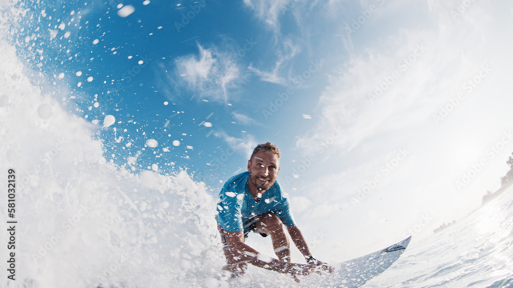 Happy surfer rides and smiles. Young man surfs the ocean wave in the Maldives and smiles Happy surfer rides and smiles. Young man surfs the ocean wave in the Maldives and smiles