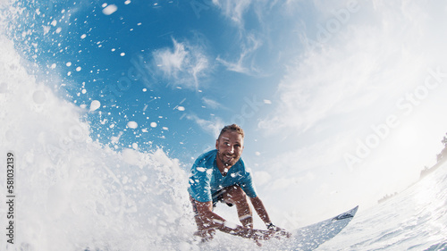Happy surfer rides and smiles. Young man surfs the ocean wave in the Maldives and smiles