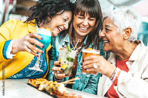 Canvas Print Happy senior women drinking cocktail glasses sitting at bar table - Group of bes