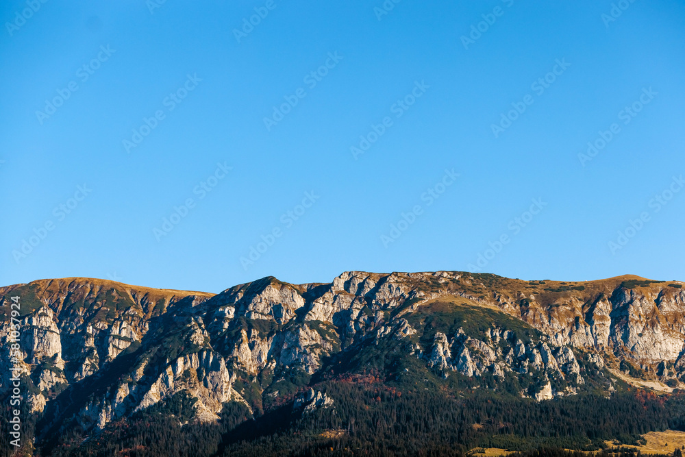Mountain top on blue sky background on sunny day.