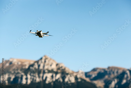 Drone flying over mountains top on blue sky background. © Bostan Natalia