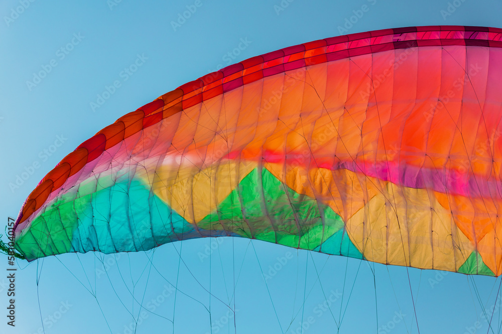 Obraz premium Background of colorful paraglider wing and blue sky.