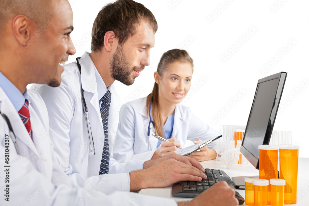 Portrait of Doctors Looking at Laptop and Writing on Clipboard Portrait of Doctors Looking at Laptop and Writing on Clipboard