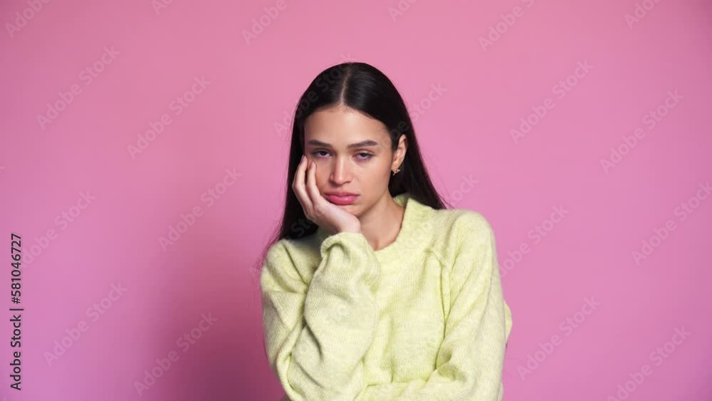 bored woman in studio against pink background bored woman in studio against pink background