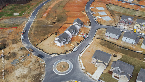 Roundabout traffic circle in new development residential neighborhood with two story houses under construction, building envelope in Flowery Branch, Georgia, USA