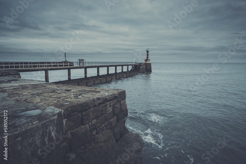 pier with boardwalk and bell tower in the sea