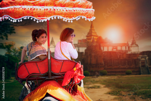 two woman riding on elephant walking in ayutthaya world heritage site of unesco one of most popular traveling destination in thailand photo