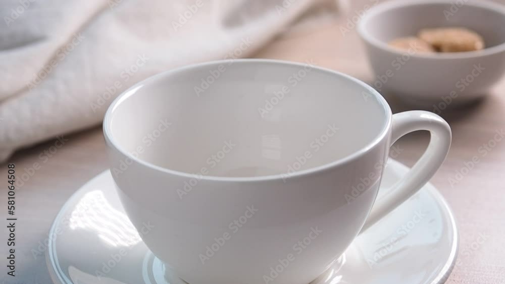 Pour instant coffee into a cup. Coffee cup and saucer on the table, top view. Pour instant coffee into a cup. Coffee cup and saucer on the table, top view.