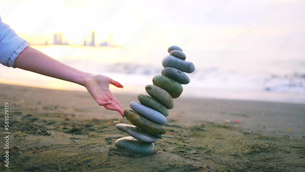 The falling Zen pyramid of stones on the ocean beach ,the concept of the idea of imbalance or psychological problems