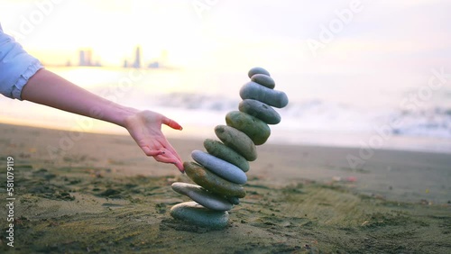 The falling Zen pyramid of stones on the ocean beach ,the concept of the idea of imbalance or psychological problems