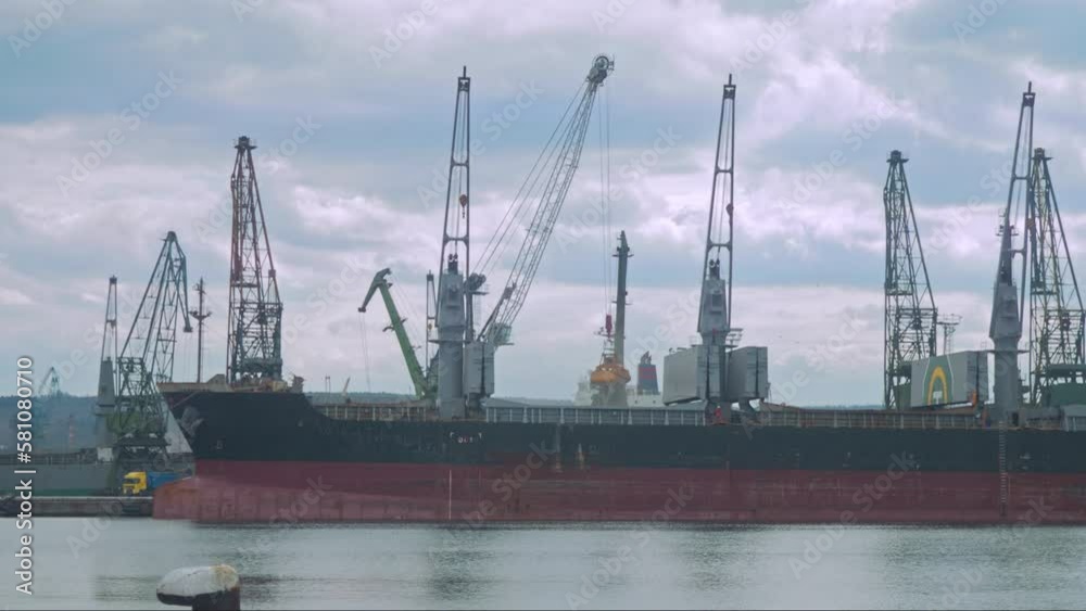 Black Sea grain export deal. Loading grain cargo vessel with grab. Several cranes are immersed at the same time Black Sea grain export deal. Loading grain cargo vessel with grab. Several cranes are immersed at the same time