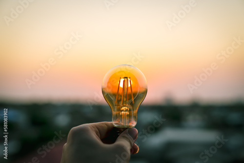 Hand business man holding light bulb. Alternative energy, idea, saving electricity innovation and inspiration concepts. 
