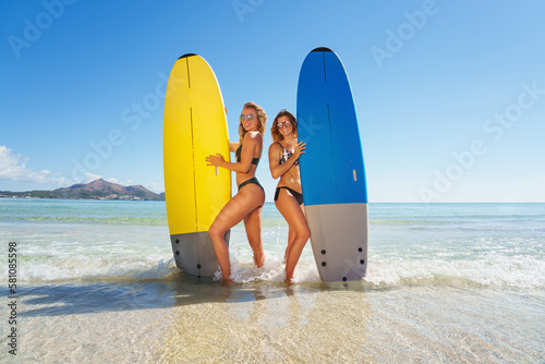 Happy young girls with a surf board on the beach Vacation.
