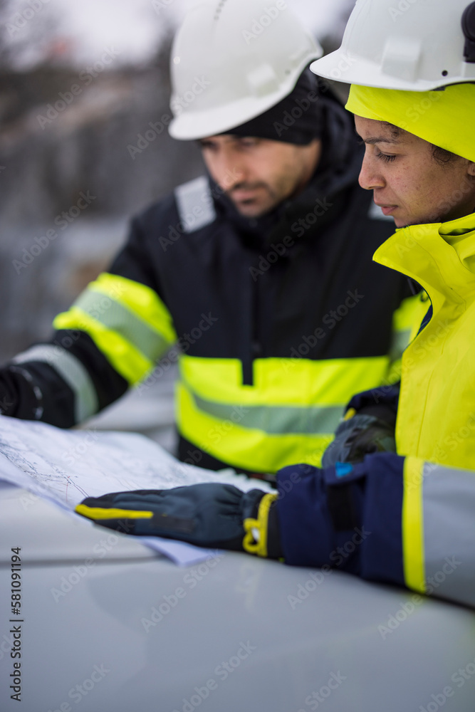 Construction engineers discussing project at construction site Construction engineers discussing project at construction site