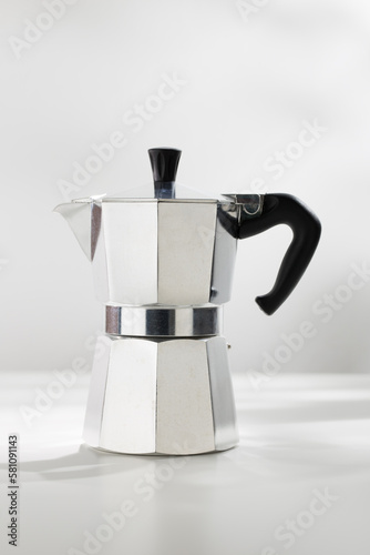 Moka pot espresso machine on a white table.