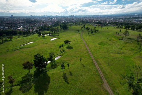 Aerial view of large green fields in adjoining settlements and daylight