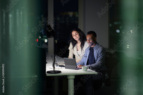 Man and woman working late in office photo