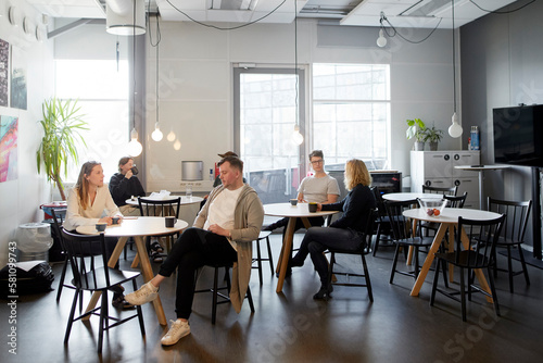 People talking while having break in office communal area