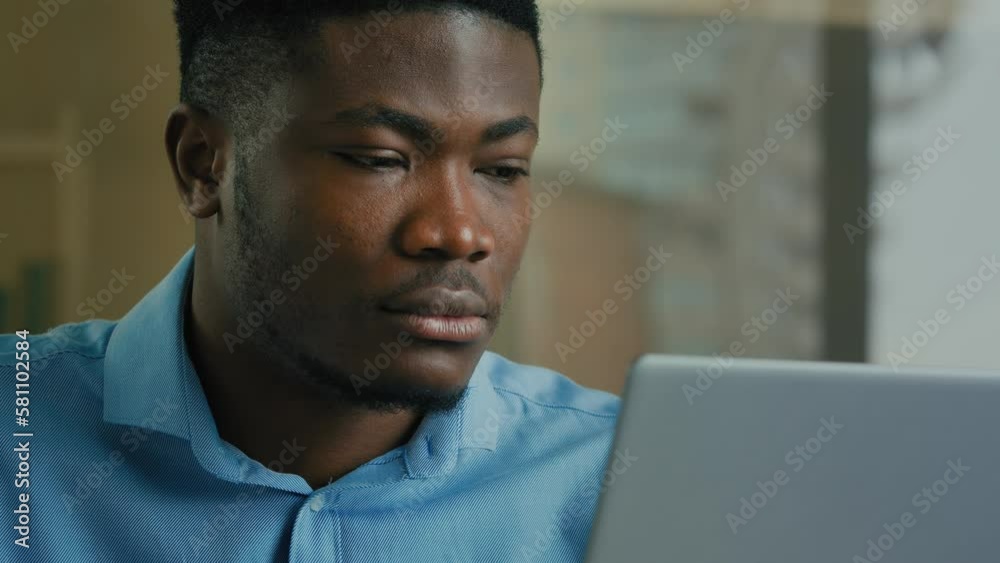 Focused businessman African american ethnicity man executive worker look at laptop screen working in home office typing email male entrepreneur use computer online searching information on internet Focused businessman African american ethnicity man executive worker look at laptop screen working in home office typing email male entrepreneur use computer online searching information on internet