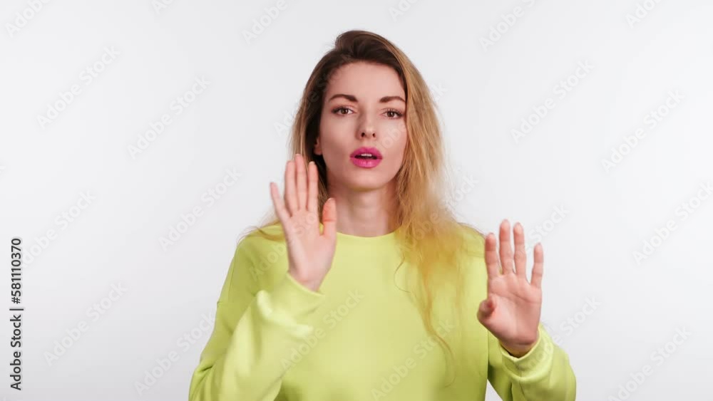 Woman showing no gesture, stop, disagreement end expression. Serious lady in yellow sweatshirt, no way ignore finish emotion. Body language concept, studio isolated on white background Woman showing no gesture, stop, disagreement end expression. Serious lady in yellow sweatshirt, no way ignore finish emotion. Body language concept, studio isolated on white background