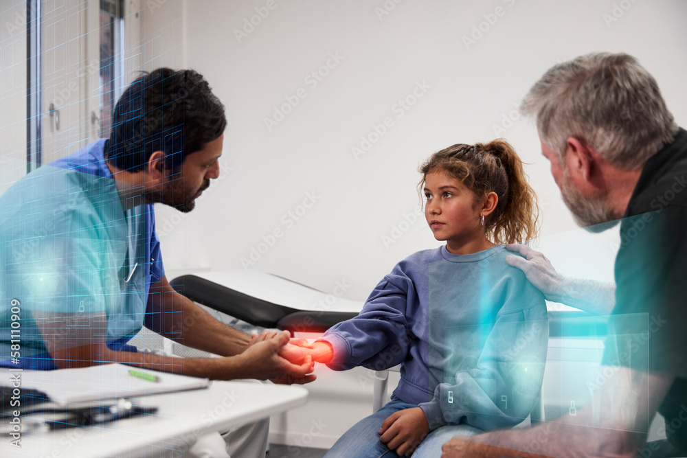 Male doctor examining girl patient's wrist during appointment Male doctor examining girl patient's wrist during appointment