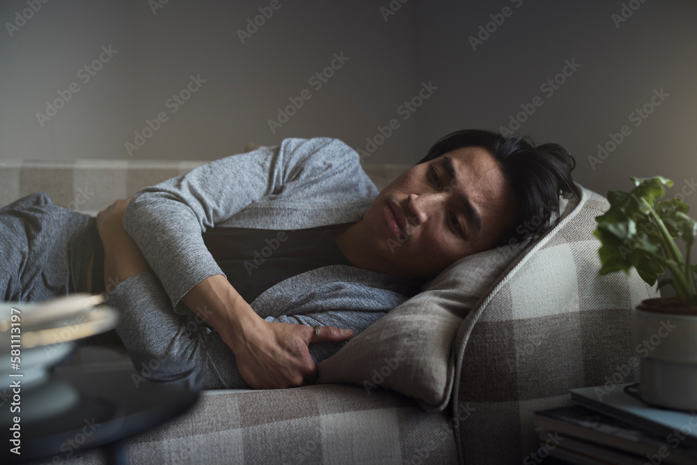 Sad man facing depression lying in bed Sad man facing depression lying in bed