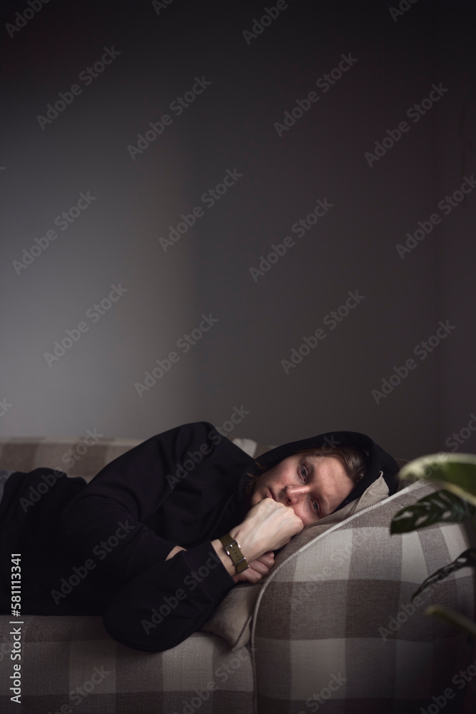 Sad man facing depression lying in bed Sad man facing depression lying in bed