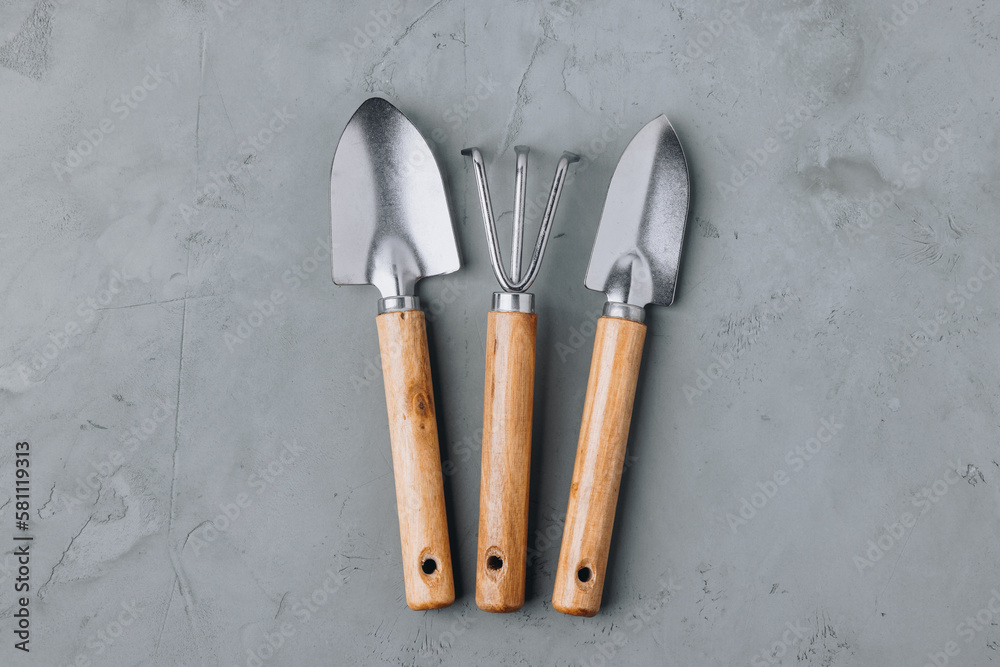 Garden tools. Wooden metal garden tools set on gray concrete stone background.