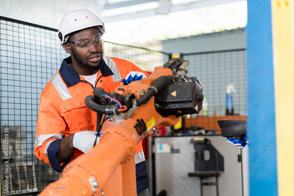 A team of male engineers meeting to inspect computer-controlled steel welding robots. Plan for rehearsals and installation for use.
