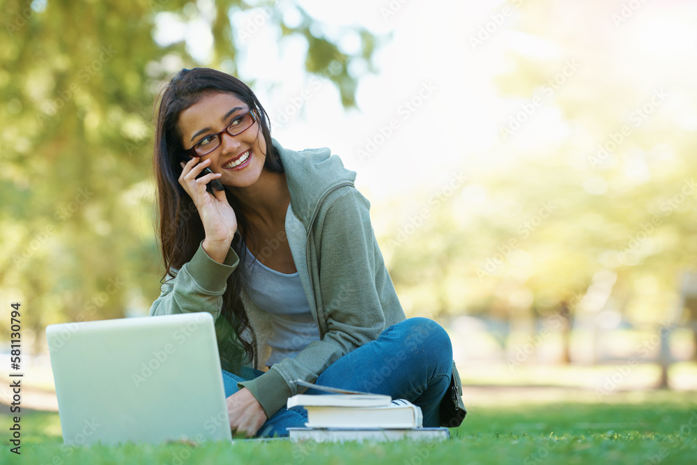 Meet me in the park for a study session. A young student speaking on her cell while sitting in the park with a laptop and testbooks. Meet me in the park for a study session. A young student speaking on her cell while sitting in the park with a laptop and testbooks.