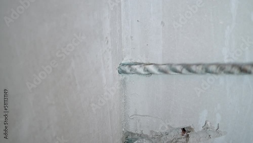 Close up Drilling for laying air conditioning pipes through the wall. Builder drills reinforced concrete with a heavy duty powerful hammer drill