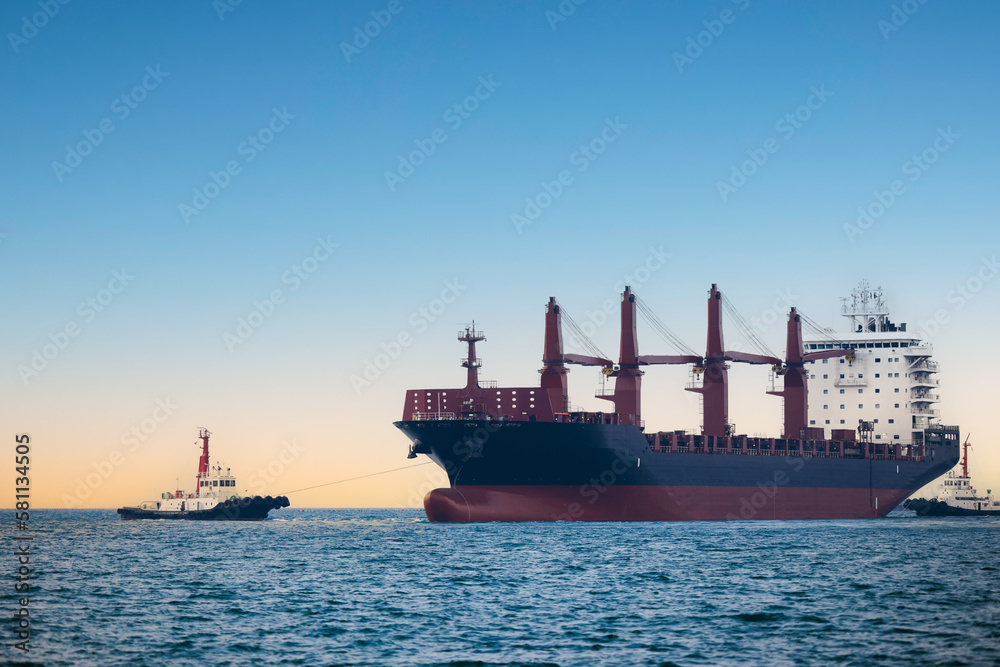 large carrier ship floating  afternoon in sea, tugboat dragging container ship, blue sky evening background and sea front,
