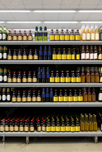 Beer bottles on shelf in supermarket with brand less labels. Suitable for presenting new beer bottles and new designs of labels among many others. 
