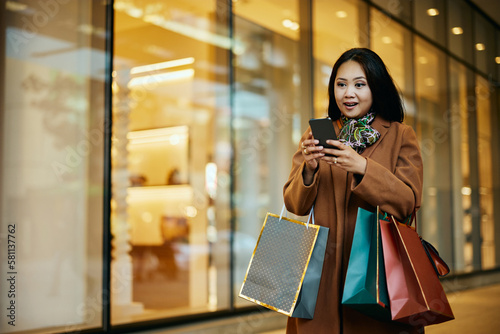 Asian woman using shopping app on mobile phone at mall. photo