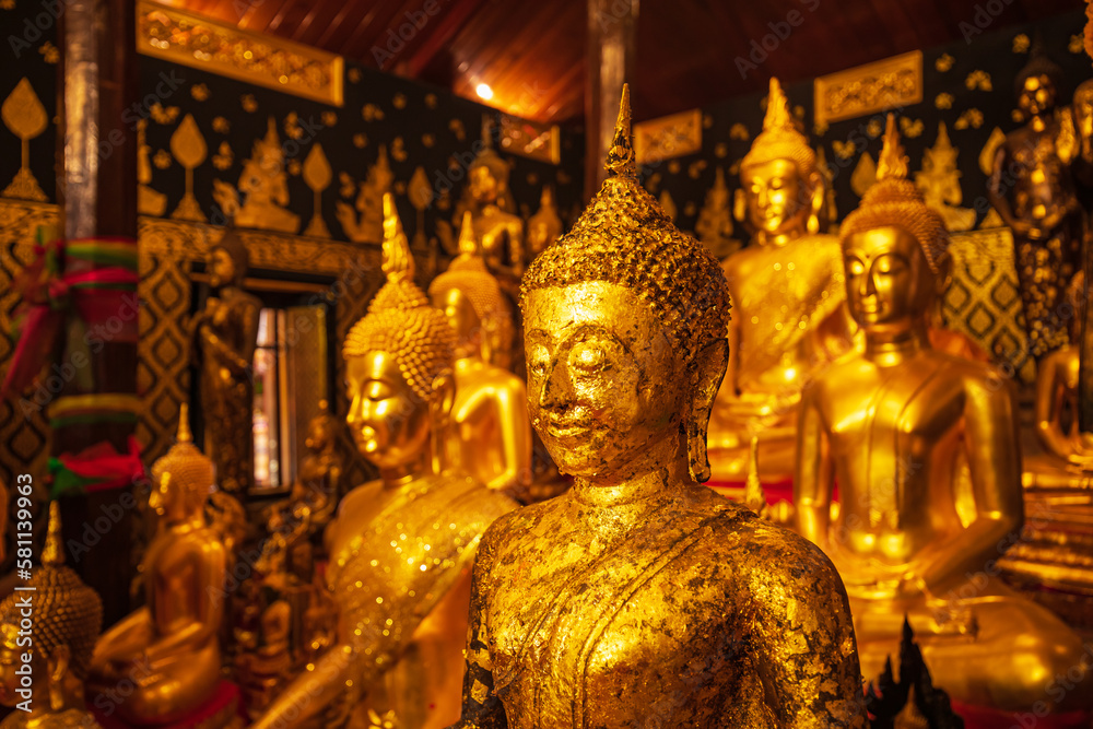 Golden group buddha faces statue meditation sitting with a Golden Buddha background up down and sitdown.