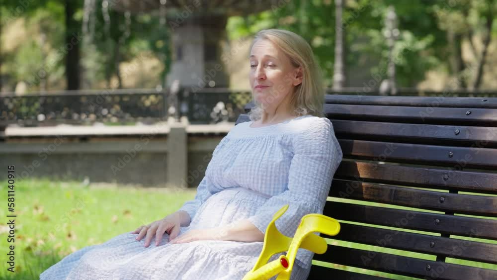 Happy senior woman resting on bench in summer park, rehabilitation after injury Happy senior woman resting on bench in summer park, rehabilitation after injury