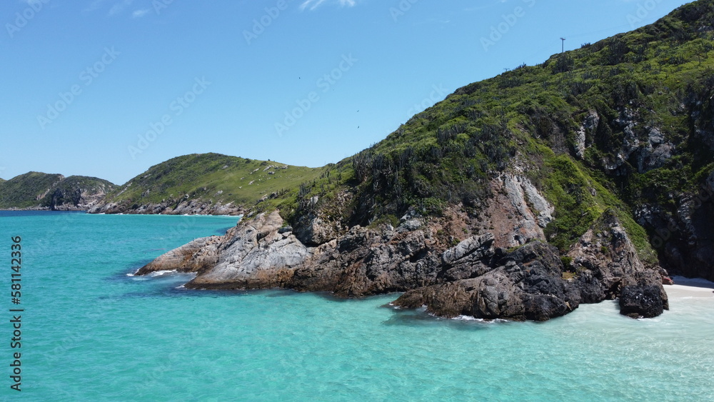 Fototapeta premium Praia paradisíaca com água azul cristalina e montanhas na paisagem
