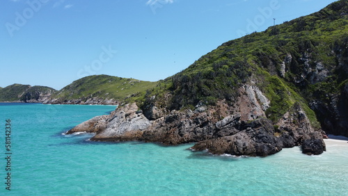 Praia paradisíaca com água azul cristalina e montanhas na paisagem (ID: 581142336)