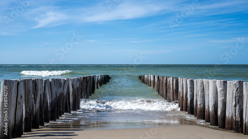 wooden breakwaters in the sea © Rick