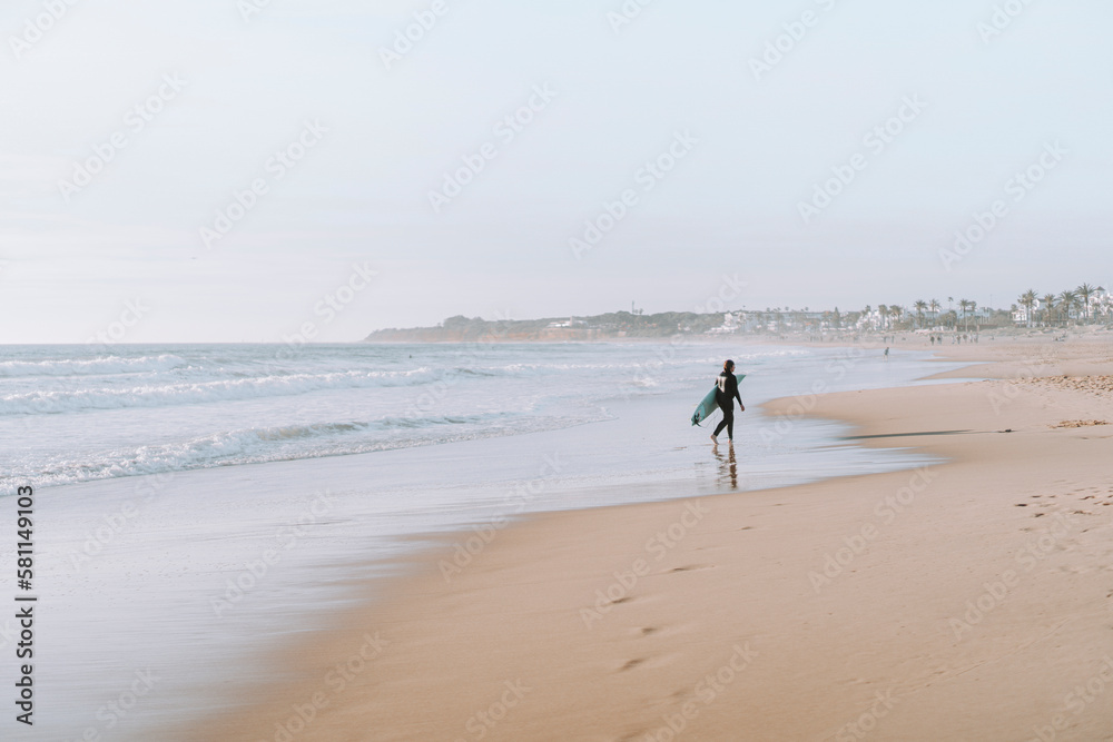 Silueta de surfista entrando en el agua al atardecer en playas de andalucia