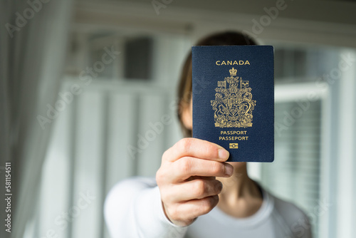 Woman holding Canadian Passport in her hand, Canadian travel, Canada immigration concept
