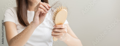 Wallpaper Mural Serious asian young woman holding brush holding comb, hairbrush with fall black hair from scalp after brushing, looking on hand worry about balding. Health care, beauty treatment, hair loss problem. Torontodigital.ca
