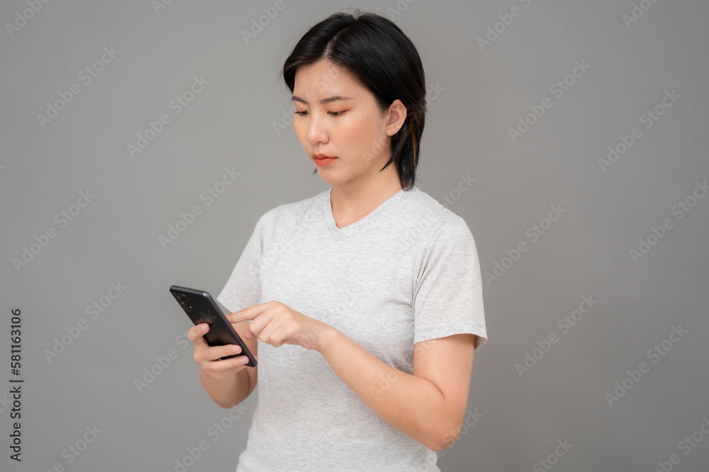 Asian woman touching a mobile phone screen with her finger to access data on the phone.. Asian woman touching a mobile phone screen with her finger to access data on the phone..